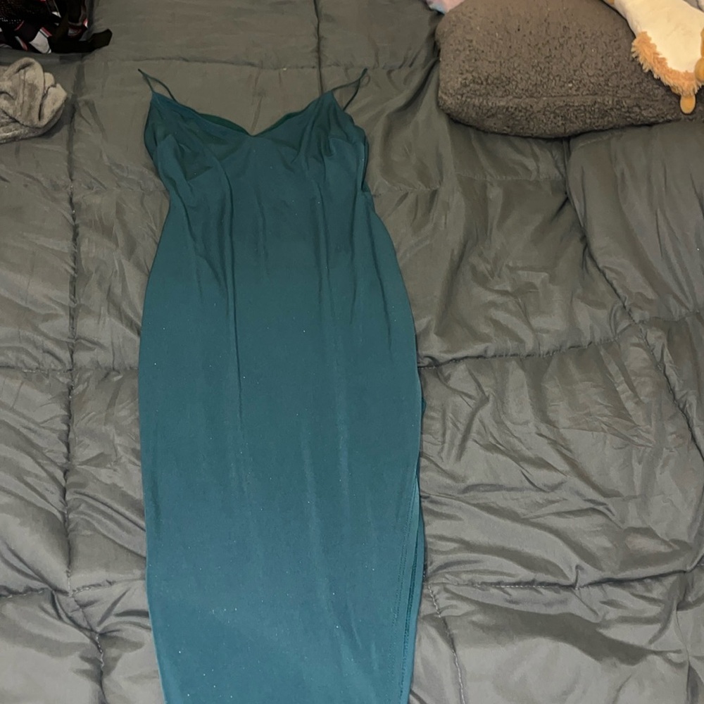 Form fitting dark olive green dress. Gorge has a high slit.